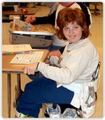 A girl sitting a table and smiling.