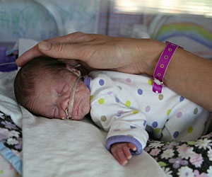 Magda Barth's hand caressing baby Emily's head
