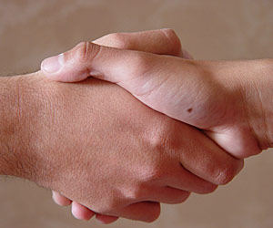 Close-up of two people shaking hands on a special education team
