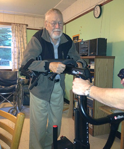 Grandpa Jim stands for the first time after his stroke, supported in the Rifton TRAM