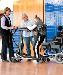 A young woman practices SMART goals using adapted equipment to help her walk in the classroom