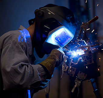 A worker in protective gear at the Rifton manufacturing facility in the USA welds a product