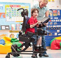A therapist assists a child in adaptive chair using a computerized screen to practice motor learning tasks 